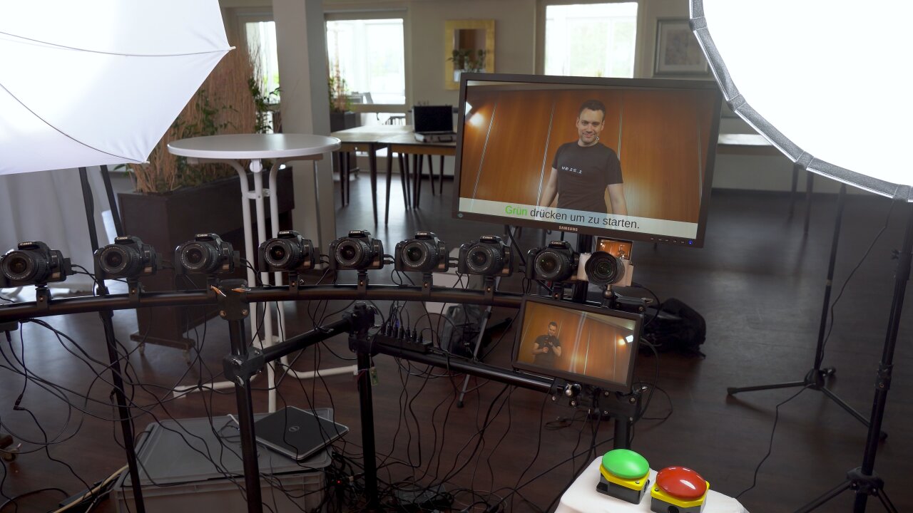 Photo of one end of the video booth where a larger screen is mounted above the cameras and a smaller screen below the cameras. The push buttons are visible in front of this part of the video booth slightly to the right.